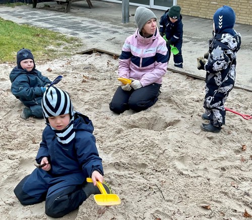 Eva og børn leger ude i sandkassen